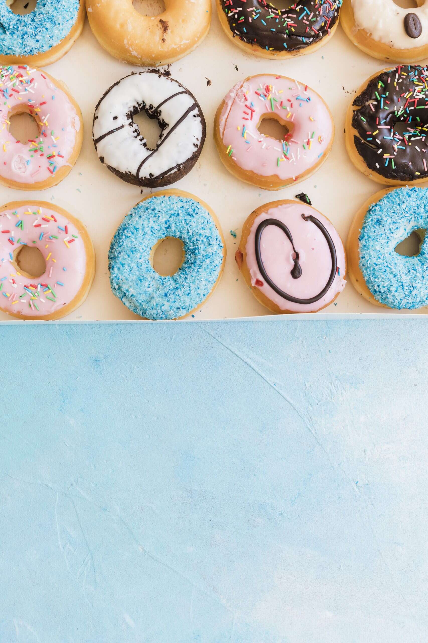 Pachete opționale 9 overhead view fresh donuts box blue backdrop scaled 1