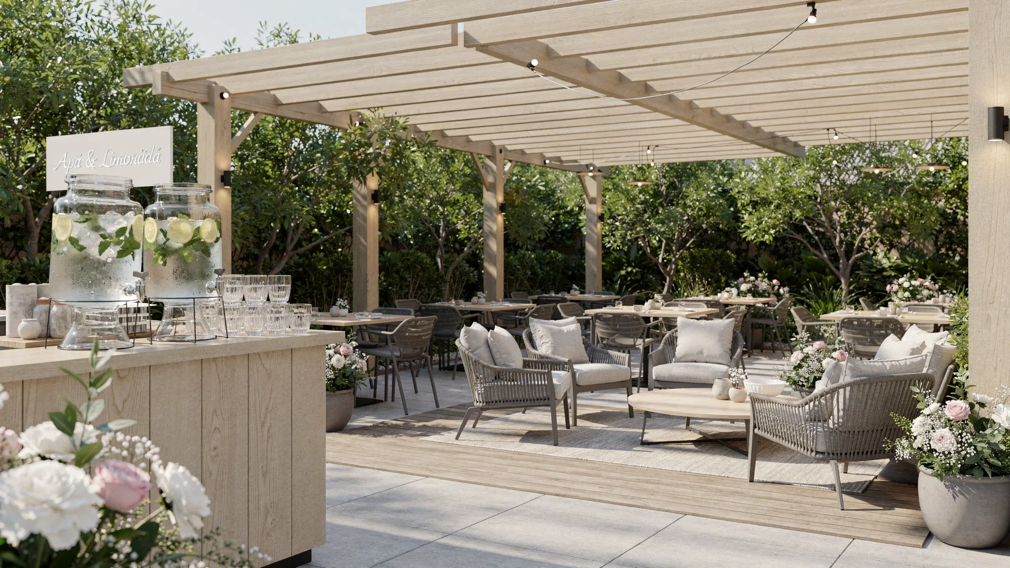 Zonă de welcome într-un restaurant aer liber, cu pergole pentru umbră, colț lounge cu fotolii, bar de apă și limonadă, aranjamente florale discrete și trasee clare către mese.