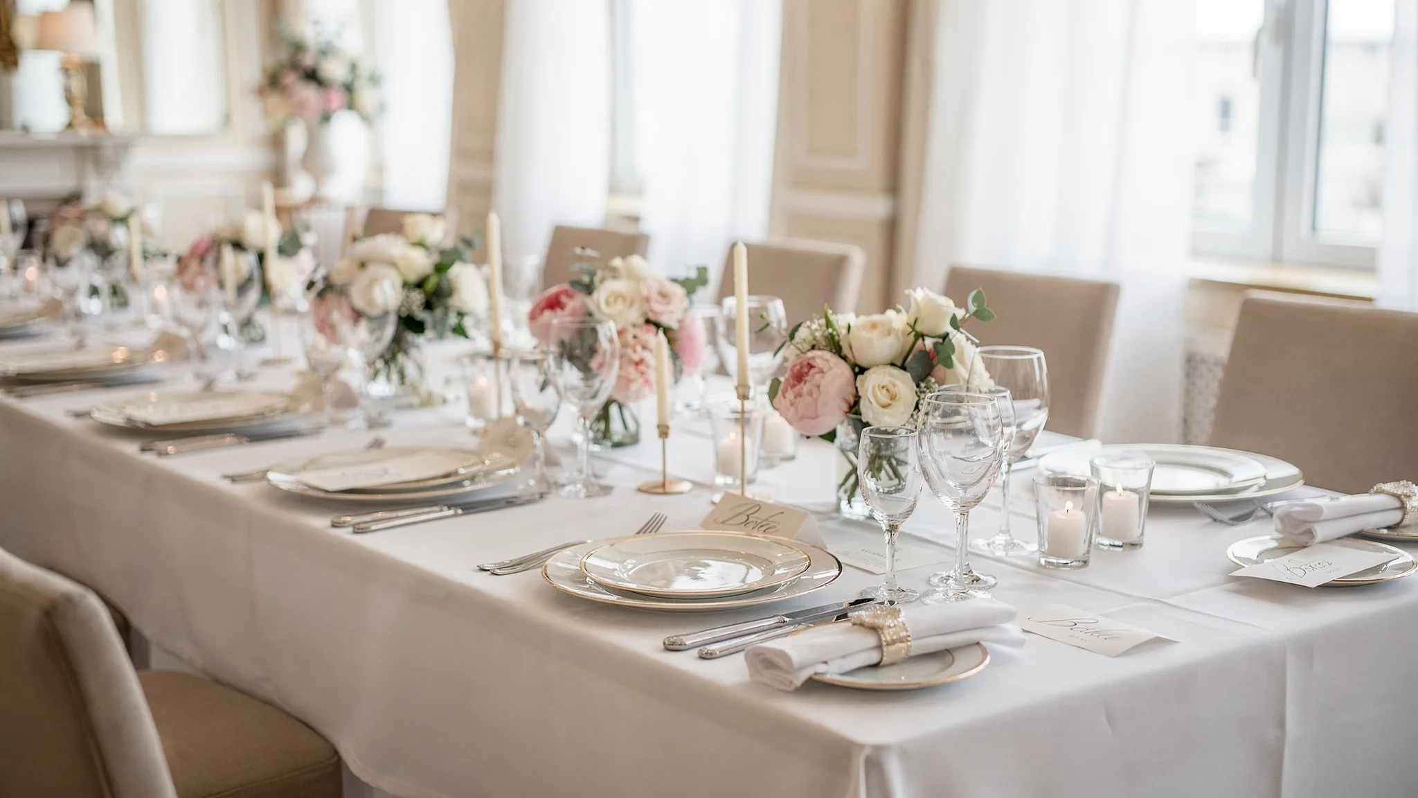 Meniu botez Jubile: opțiuni light, premium și kids friendly 2 O masă elegantă de botez, cu aranjamente florale luminoase, farfurii servite la farfurie și detalii rafinate pentru un eveniment de zi, într-un spațiu premium.